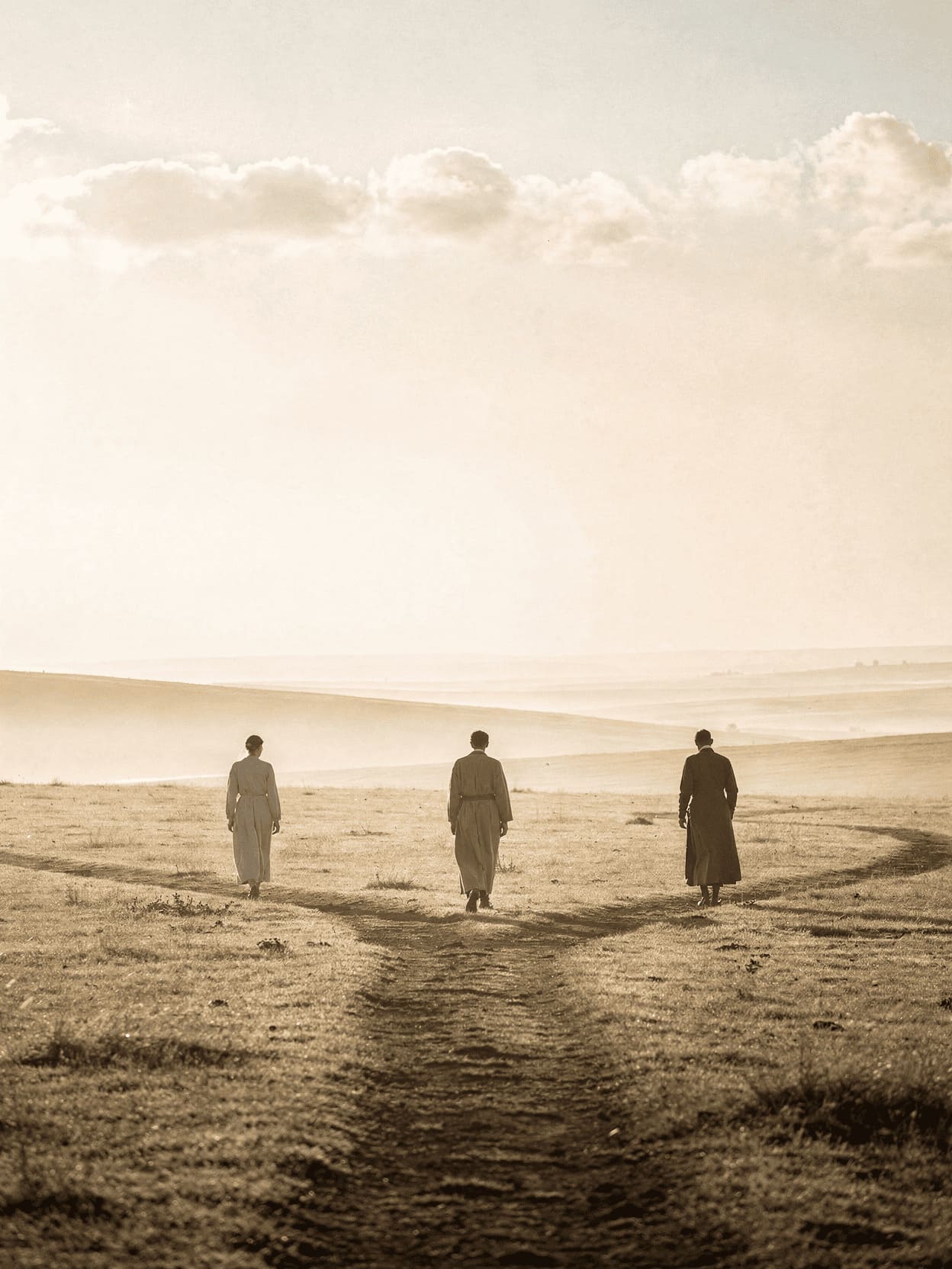 three different people walking separate paths towards distant horizons